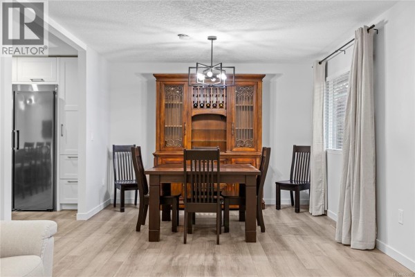 Dining room with a dark wood table and chairs, hutch, and window with curtains. - 1350 Greenwood Way, French Creek