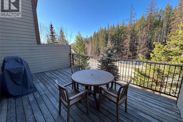 Living room with a sofa, coffee table, entertainment center, and a balcony door. - 1351 Gerry Sorensen Way Unit# N3a, Kimberley