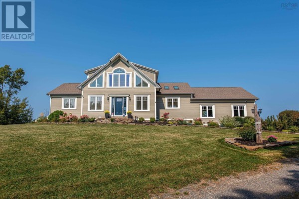 Main entrance of the house showcasing a symmetrical design and landscaped yard. - 13573 Highway 6, Wallace Bridge