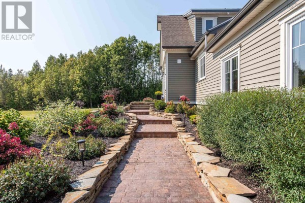 Pathway leading to the house, bordered by flower beds and stone edging. - 13573 Highway 6, Wallace Bridge