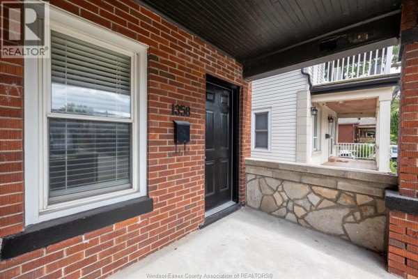 Close-up of the upper unit entrance with a black door, brick facade, and porch. - 1358 Pierre Unit# Upper, Windsor