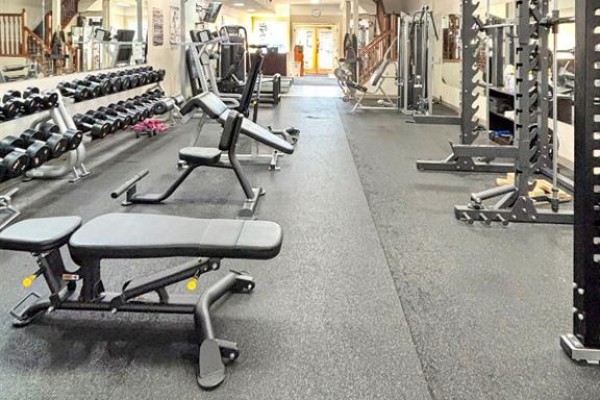 Additional workout space featuring weight racks, benches, and mirrors - 136 49 Avenue W, Claresholm