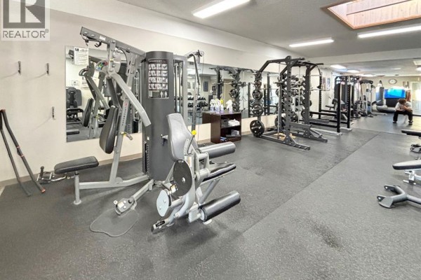 Gym floor with benches, dumbbells, and open space for workouts - 136 49 Avenue W, Claresholm