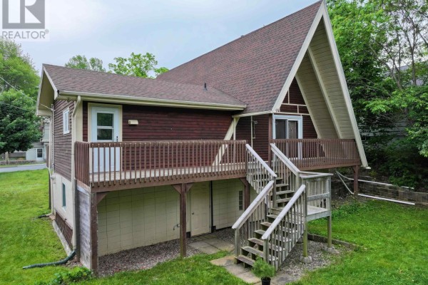 View of the A-frame house from the backyard, showing the deck and stairs. - 136 Empire Street, Bridgewater