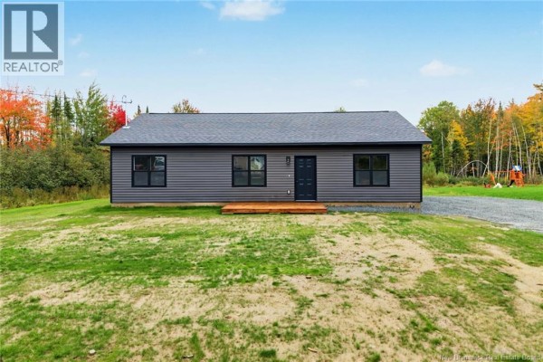 Front exterior of a single-story dark grey vinyl house with a dark grey roof and four windows. - 136 Horseman Road, Fredericton Junction