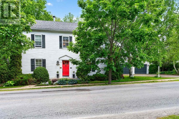 White house exterior with mature trees and lush garden in front. - 136 Old Danforth Road, Alnwick/haldimand