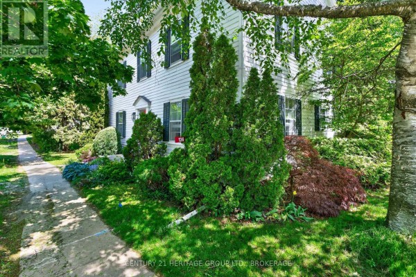Close-up of white siding on house with green shutters and landscaping. - 136 Old Danforth Road, Alnwick/haldimand