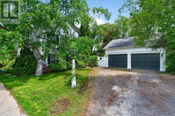 Two-car garage with dark green doors, white trim, and white gate. - 136 Old Danforth Road, Alnwick/haldimand
