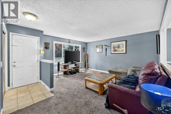 Interior hallway with blue walls, mirrored closet doors, and two white doors. - 136 Templeview Place Ne, Calgary