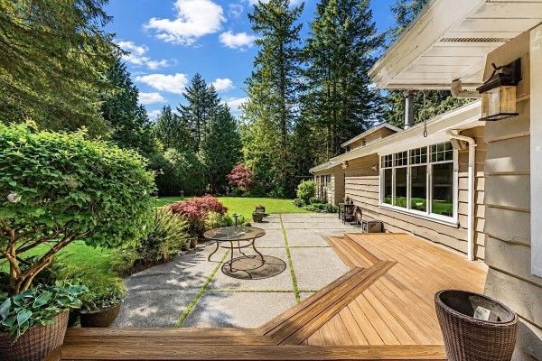 Front exterior view of a one-story home with a concrete driveway, lush green lawn, and manicured landscaping. - 13666 30 Avenue, Surrey