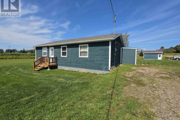 Rear view of a green sided bungalow with an attached shed and rural landscape. - 1366b Pownal Road, Alexandra