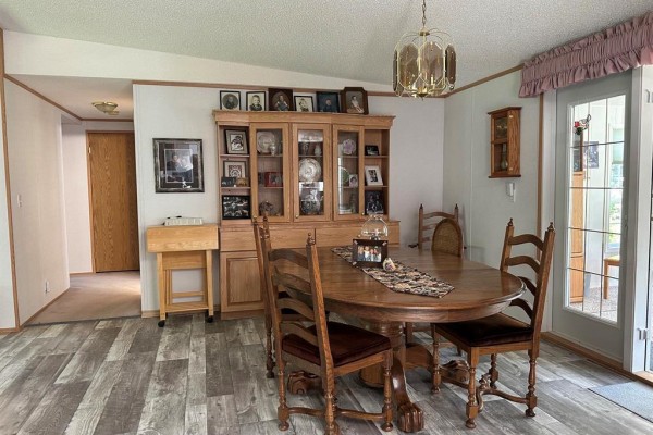 Dining room with wooden table, chairs, hutch, and glass doors. - 1367 Queens Street, Birtle