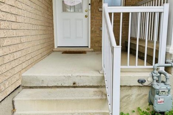 Front porch with concrete steps, a white door, white railings, and a gas meter on the side. - 1369 Countrystone Drive, Kitchener