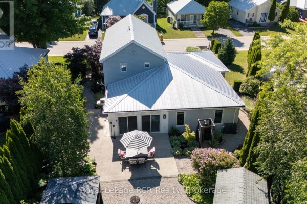 Rear aerial view of the house with sliding doors leading to a concrete patio with an umbrella. - 137 - 383 Mcnabb Street, Saugeen Shores