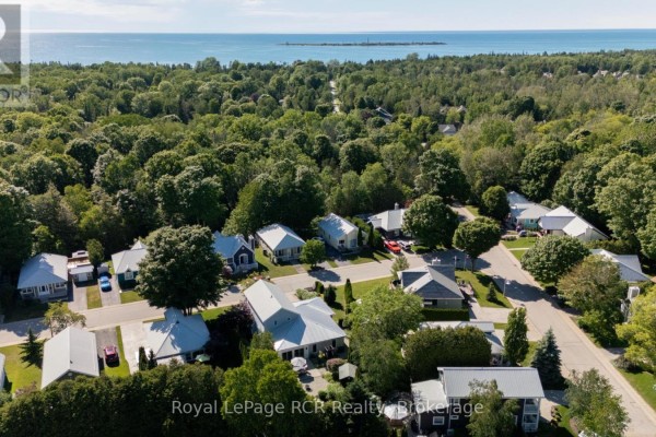 Aerial view of the neighbourhood with trees and houses, and a distant view of the lake. - 137 - 383 Mcnabb Street, Saugeen Shores