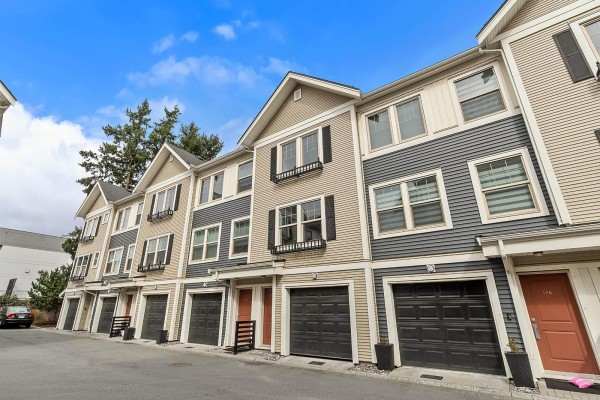 A balcony with outdoor furniture covered by tarps and a view of townhouses. - 137 32633 Simon Avenue, Abbotsford