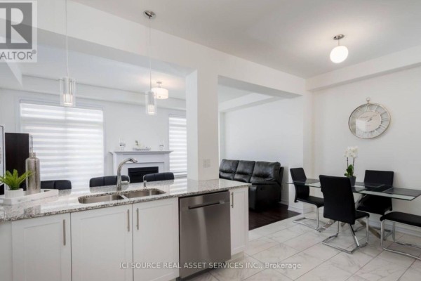 Open concept living and dining area with black table and chairs, view of kitchen island. - 137 Allegranza Avenue, Vaughan