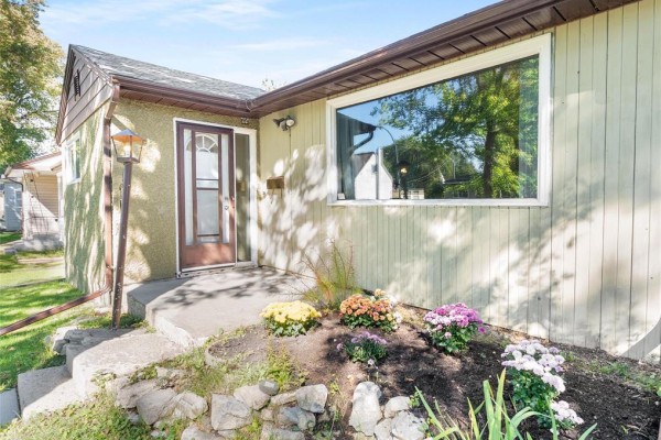 Close-up of the front entrance showing a glass-paned door and large picture window. - 137 Kilbride Avenue, Winnipeg