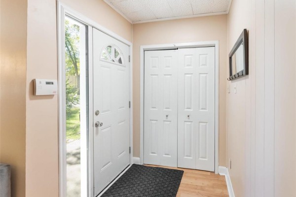 Interior entryway with beige walls, a white door, and a double closet with bi-fold doors. - 137 Kilbride Avenue, Winnipeg