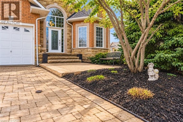 Close-up of a paved walkway leading to a front door with stone accents. - 137 Pinehill Drive, Stoney Creek