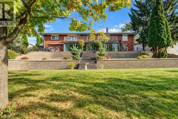 Front facade of a red brick bungalow with a well-maintained lawn and landscaping. - 1370 Thorman Place, Cambridge