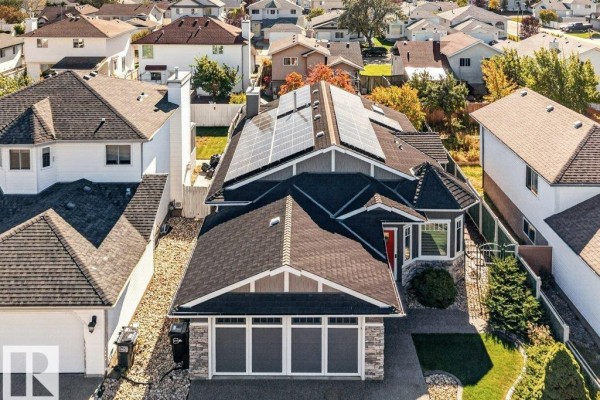 Aerial view of a residential house with dark grey siding, a dark roof, and solar panels installed. - 13725 - 131b Avenue Nw, Edmonton