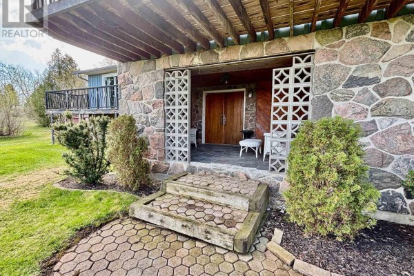Front entrance with stone facade, decorative concrete screens, and double wooden doors. - 1374 Regional Road 12 Road W, Brock