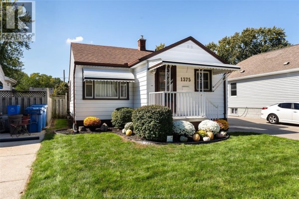 Side view of the white house with a driveway and part of the backyard. - 1375 Bernard Road, Windsor
