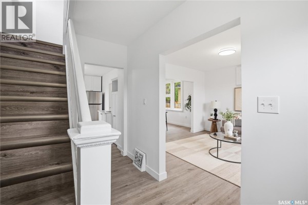 Kitchen with white cabinets, stainless steel appliances, and light wood flooring. - 1376 King Street, Regina