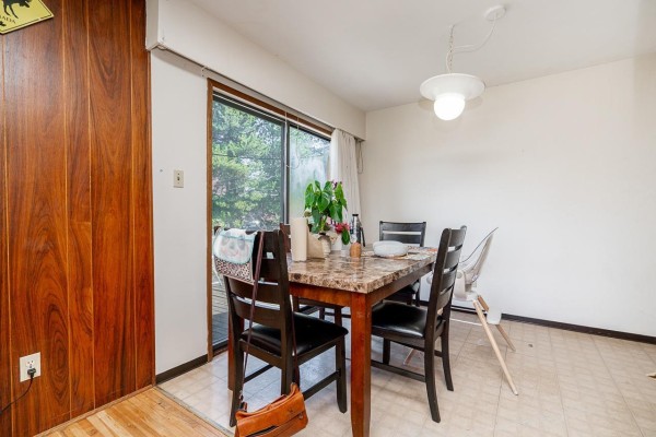 Marble-top dining table with chairs, adjacent to a sliding glass door. - 13760 Bentley Road, Surrey