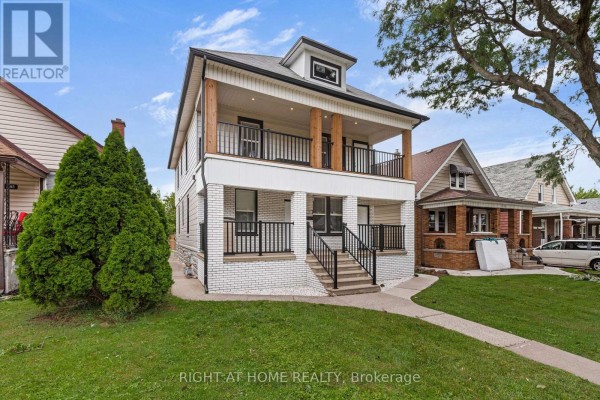 Side view of a two-story multi-family home, showing the front entrance and yard. - 1379-1381 Pierre Avenue, Windsor