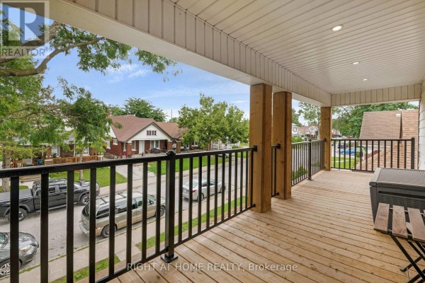 View from the upper front balcony, looking out over the street with parked cars and trees. - 1379-1381 Pierre Avenue, Windsor
