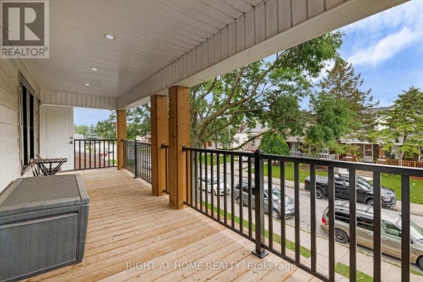 View from the upper front balcony, showcasing the wooden deck and street view. - 1379-1381 Pierre Avenue, Windsor