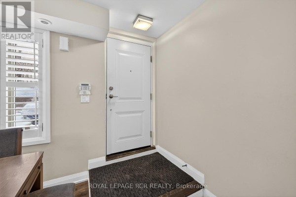 Interior view of a home entrance with a white door, wood floor, and beige walls. - 138 - 326 John Street, Markham