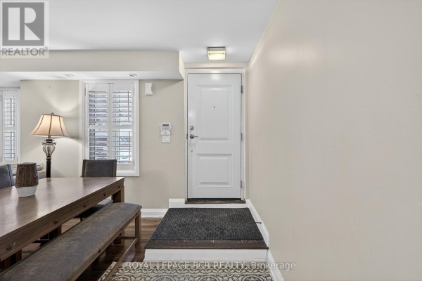 Interior view of a dining area next to a home entrance with a white door. - 138 - 326 John Street, Markham