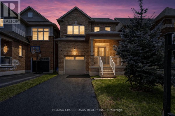 Twilight exterior of a two-story brick house with a covered porch and garage. - 138 Angus Drive, Ajax