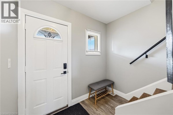 Interior entryway with a white door, bench, small window, and staircase. - 138 Cameron Avenue N, Hamilton