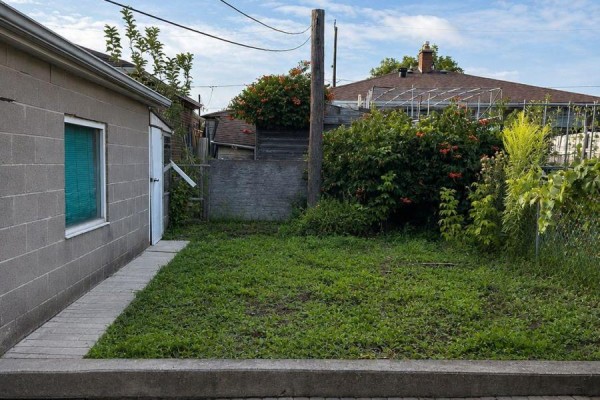 Backyard with grass, concrete walkway, and mature trees. - 138 Lomar Drive, Toronto