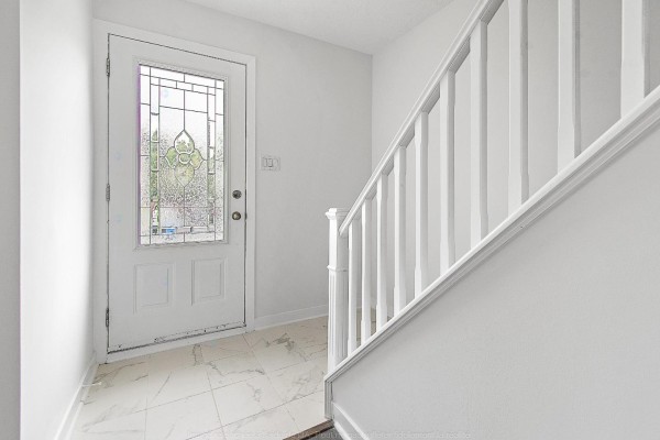 Interior entryway with a white door with frosted glass and a white staircase railing. - 138 Rue Bourgeau N., Gatineau