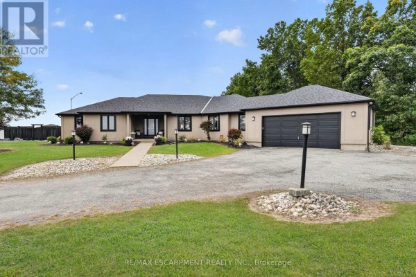 Exterior view of a large, single-story home with a garage and manicured lawn during the day. - 1380 Eighth Avenue Louth, St  Catharines
