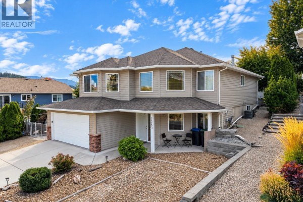 Front entrance of a beige house with a covered porch and seating area. - 1380 Loseth Drive, Kelowna