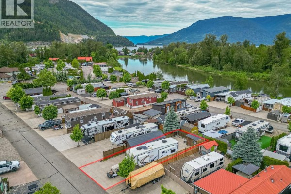 Aerial view of a RV park with multiple lots, RVs, and cabins near a lake. - 1383 Silver Sands Road Unit# 109, Sicamous