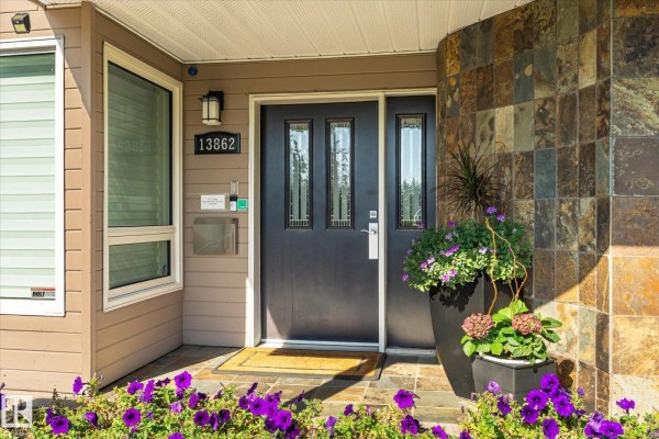 Detailed view of the front door with house number 13862, mail slot, and stone facade. - 13862 Ravine Dr Nw, Edmonton