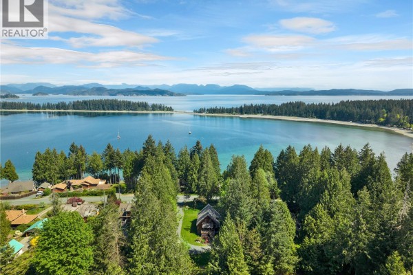 Expansive aerial view of Quadra Island, showcasing a calm blue bay, distant islands, and a dense forest. - 1387 Heriot Bay Rd, Quadra Island