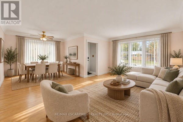 Living and dining room with light pink walls, hardwood floors, and large windows. - 1388/1390 Leighland Road, Burlington