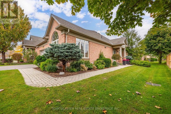 Side exterior view of brick townhouse with paved walkway and manicured lawn. - 139 - 2025 Meadowgate Boulevard, London South