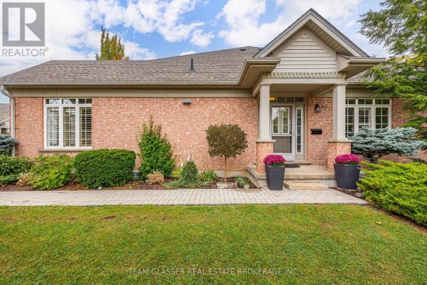 Front entrance of brick townhouse with covered porch, walkway, and potted plants. - 139 - 2025 Meadowgate Boulevard, London South