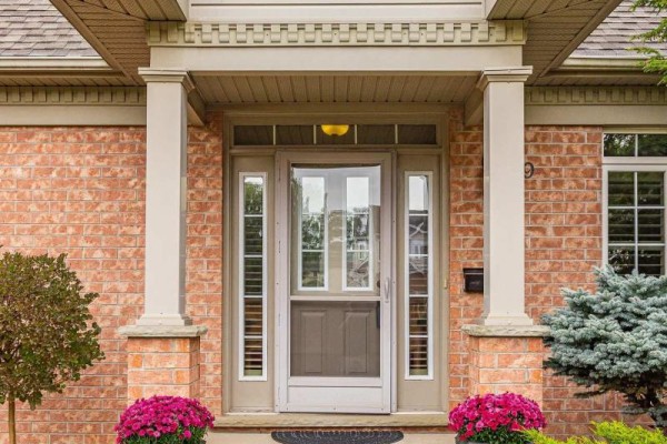 Close-up of front door with glass panes, surrounded by brick, and planters. - 139 - 2025 Meadowgate Boulevard, London South