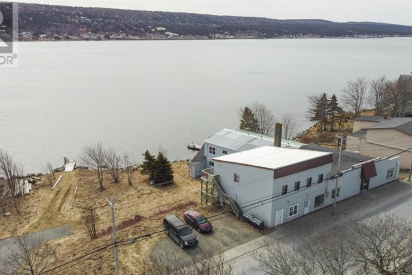 Side view of the commercial building showing the two-story section and a large warehouse area. - 139-141 Water Street, Harbour Grace