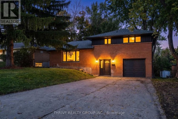 Exterior of a brick house at dusk with interior lights on and exterior lighting. - 139 Deer Park Circle, London North